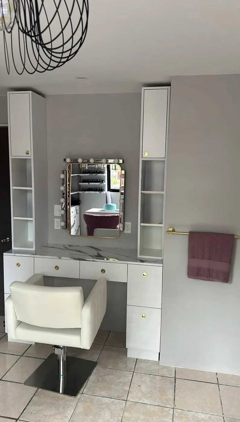 Tocador con espejo iluminado y silla blanca
